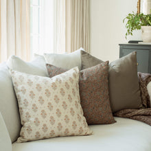 Anais blush floral pillow with a terracotta paisley pillow on a sofa
