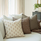 Sienna set with cream, peach floral and terracotta pillows on a sofa