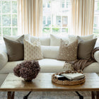 Anais floral pillow with taupe textured pillows on a sectional