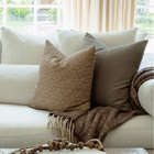 Louisa brown floral pillow with cream and tan block print pillows on an organic modern sofa