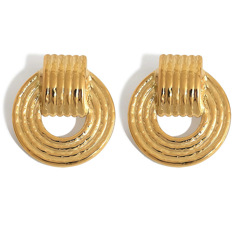 Carmela Doorknocker Earrings with textured gold finish on white background