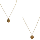 Layered zodiac coin necklace styled with other dainty chains