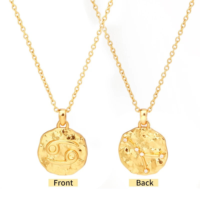 Close-up of coin pendant with etched zodiac constellation