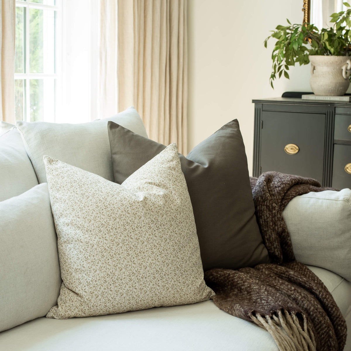 Mila ivory mini floral throw pillow cover on a neutral sofa