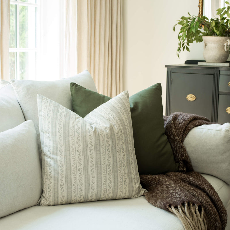 Faye ivory and blue striped throw pillow cover on a sofa