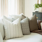 Camille pillow with ivory striped pillows on a sofa