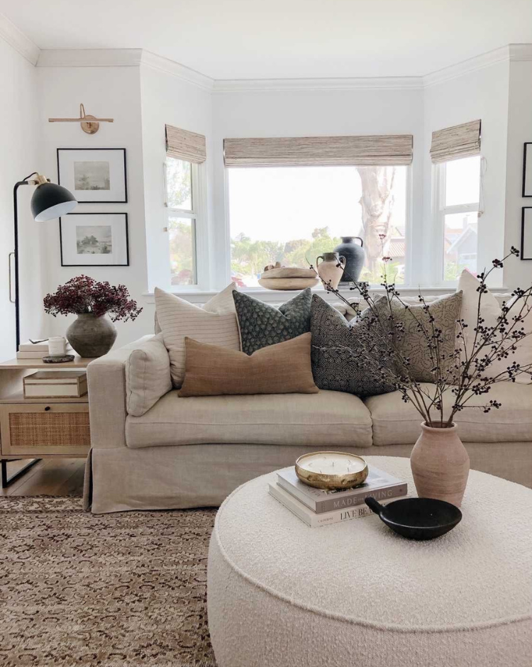 designer decorative pillow covers styled on a neutral sofa creating a warm layered living room look.