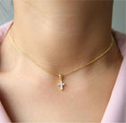 Close-up of gold Mini Cross Necklace pendant on chain
