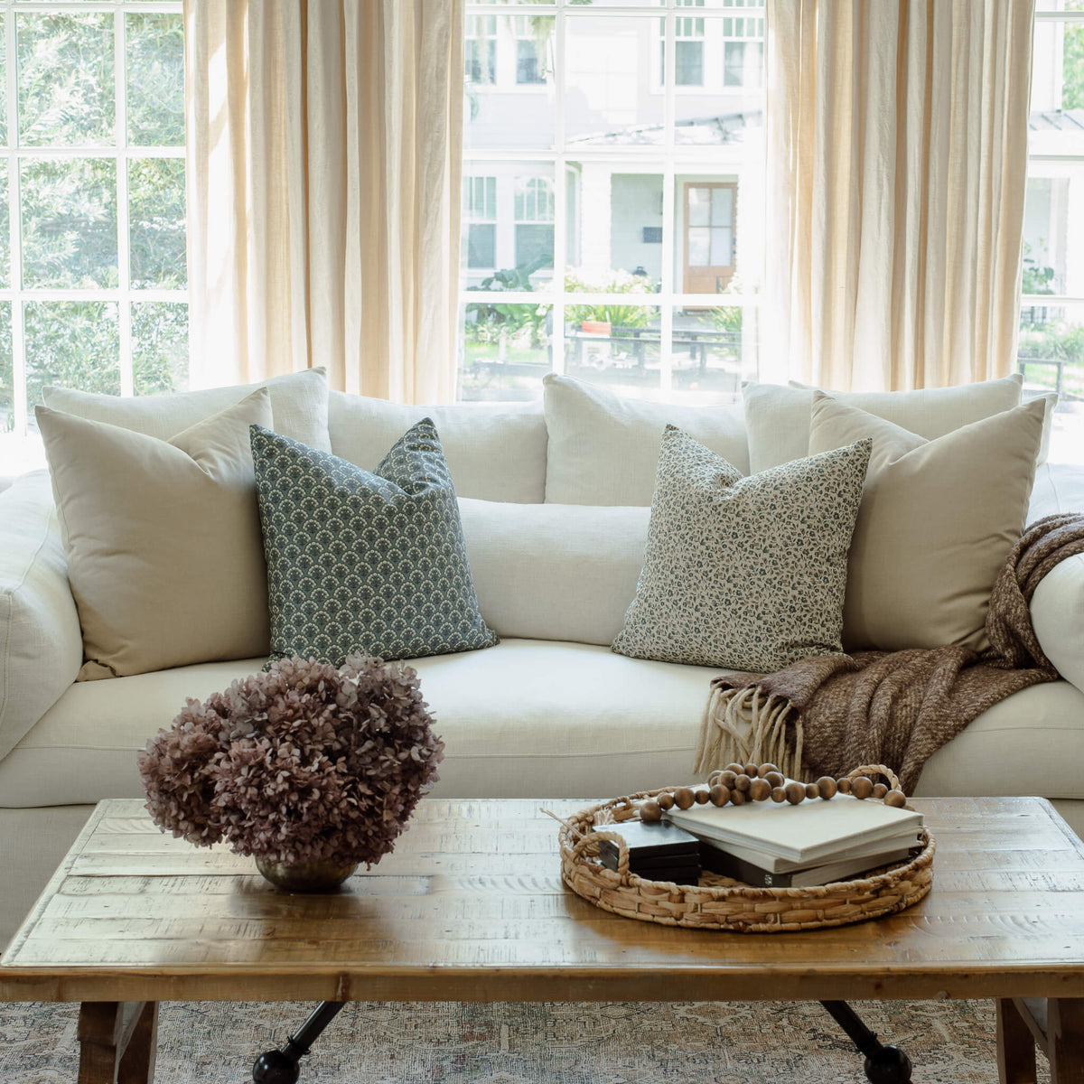 Adeline blue floral pillow with navy and ivory pillows on a sectional