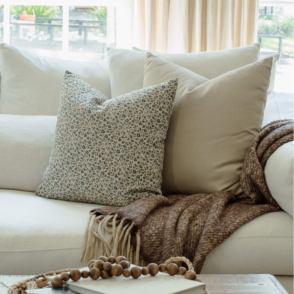 Adeline blue floral pillow in a sectional pillow arrangement, wide view