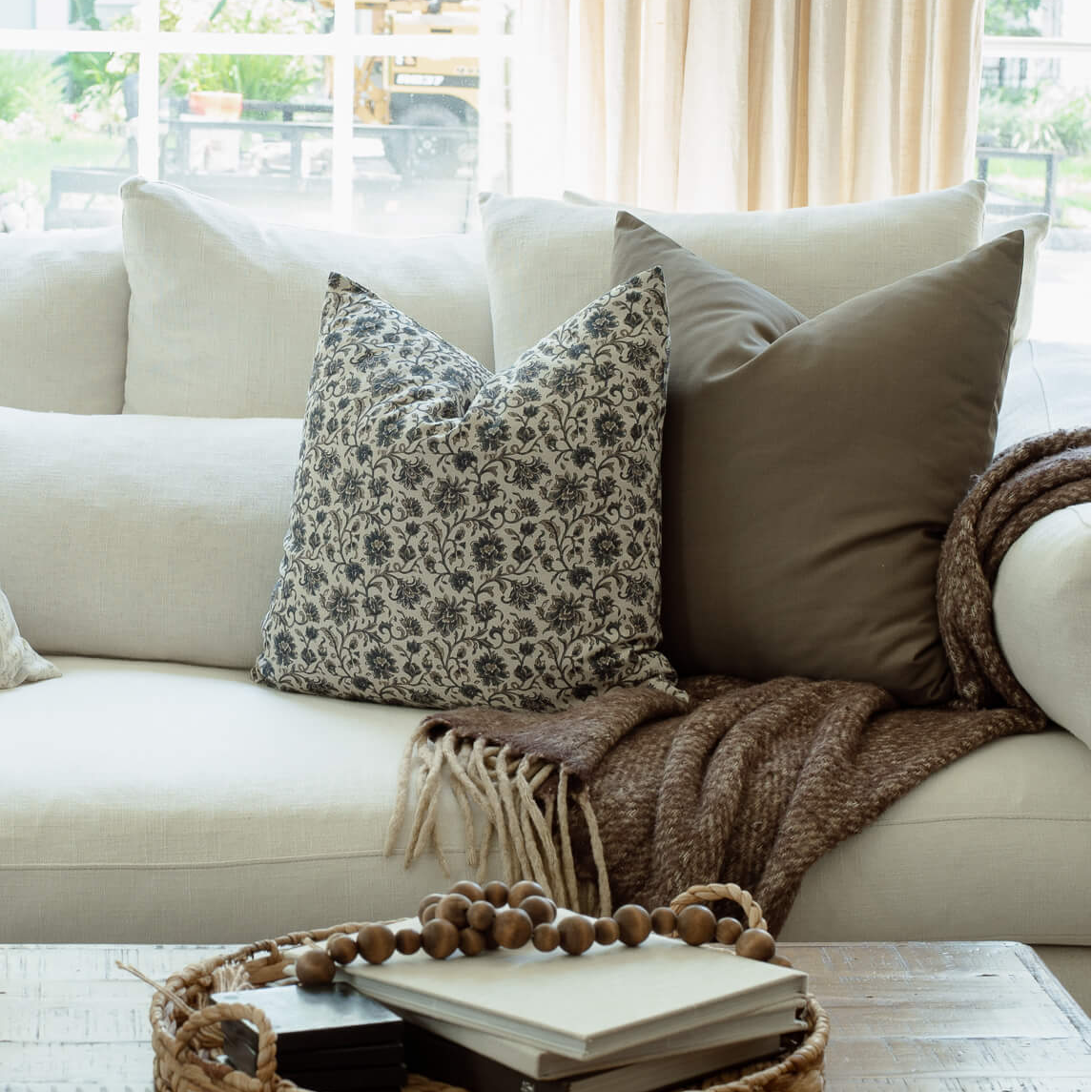 Celine blue floral pillow with ivory striped pillows in a bright living room