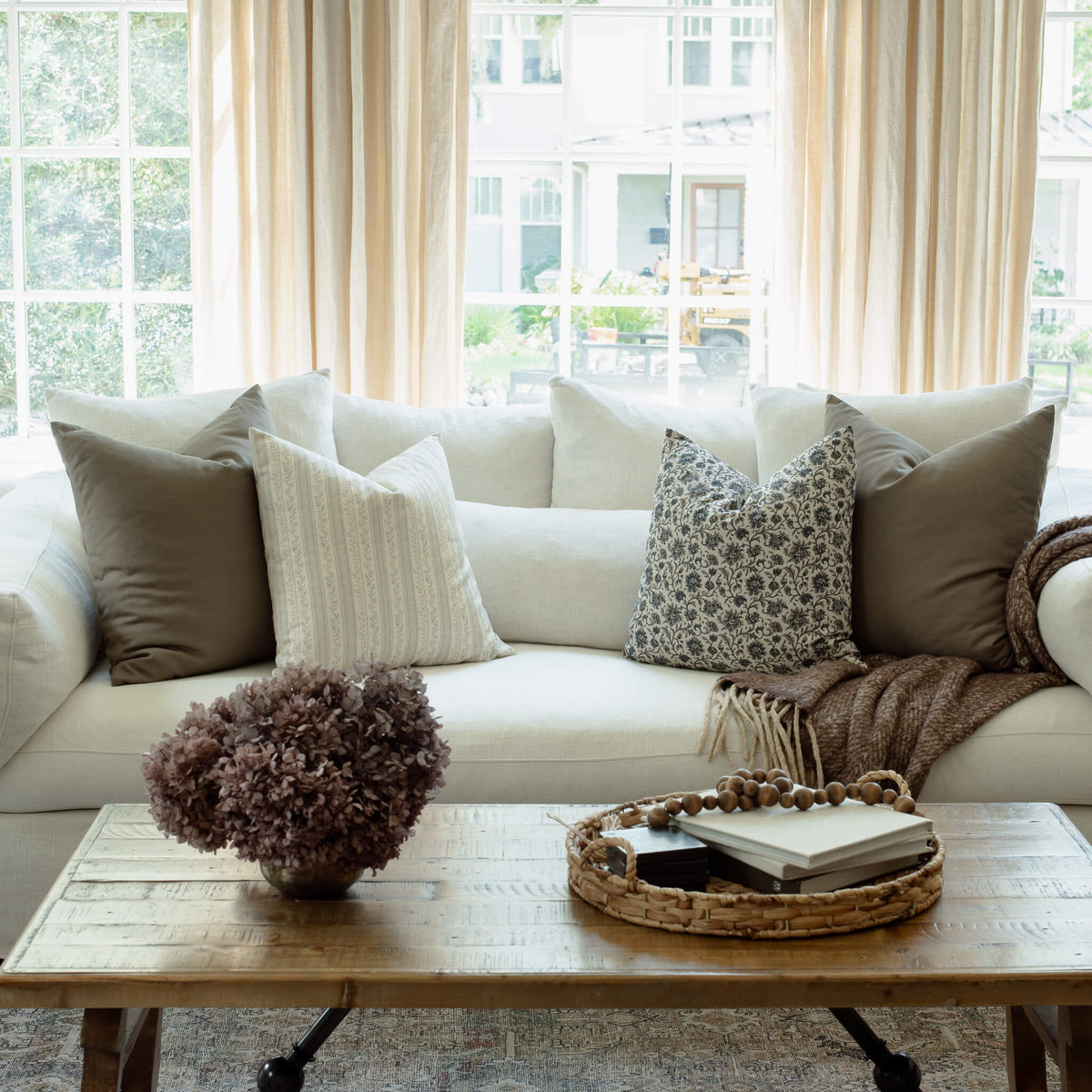 Celine navy floral pillow styled with ivory stripes on a sofa