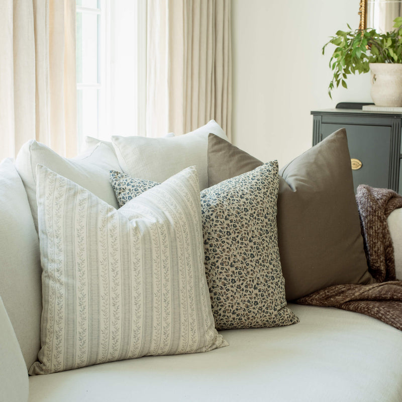 Bellamy set with neutral striped and blue floral pillows on a sofa