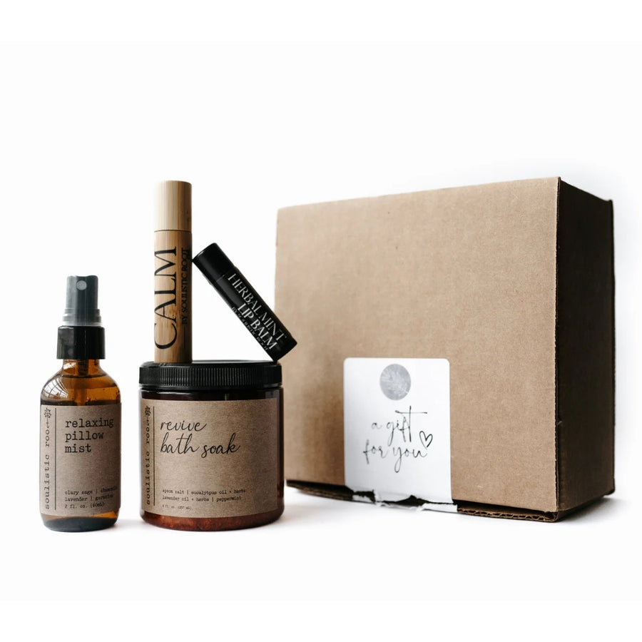 Self-care gift set with pillow mist, bath salt, roller, and lip balm