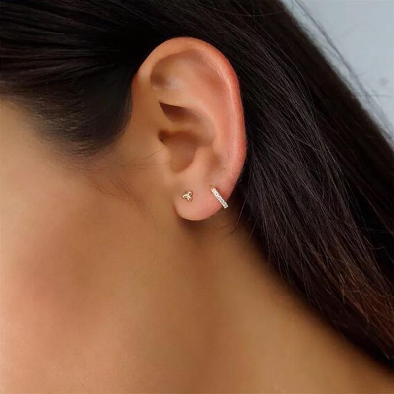 Gold huggie hoops styled in second and third piercings