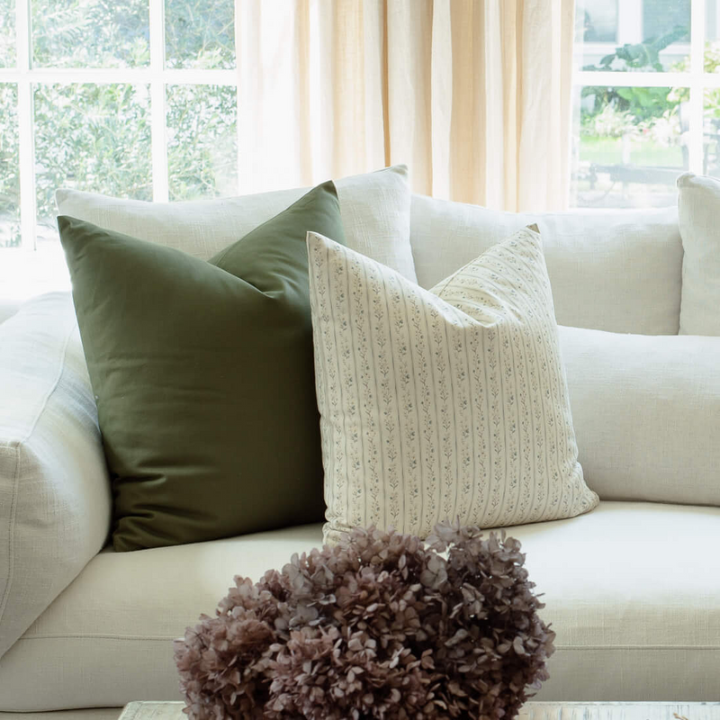 Willa blue floral stripe pillow with sage and olive pillows on a sectional