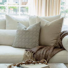 Camille botanical pillow styled on a neutral sectional