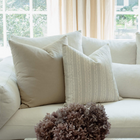Faye blue vine stripe pillow styled on a neutral sectional