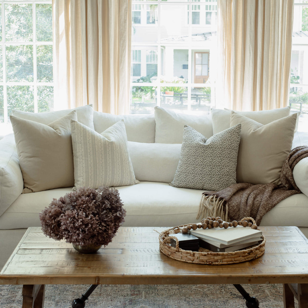 Faye striped pillow with sage and ivory pillows on a neutral sectional