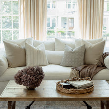 Faye striped pillow with sage and ivory pillows on a neutral sectional
