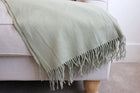 Decorative sage green blanket with stylish fringe edges