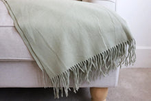 Decorative sage green blanket with stylish fringe edges