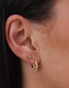 Close-up of tiny gold star stud earrings