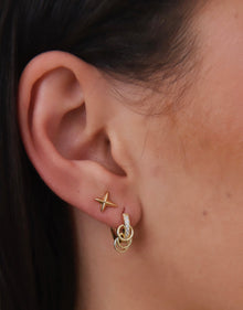Close-up of tiny gold star stud earrings