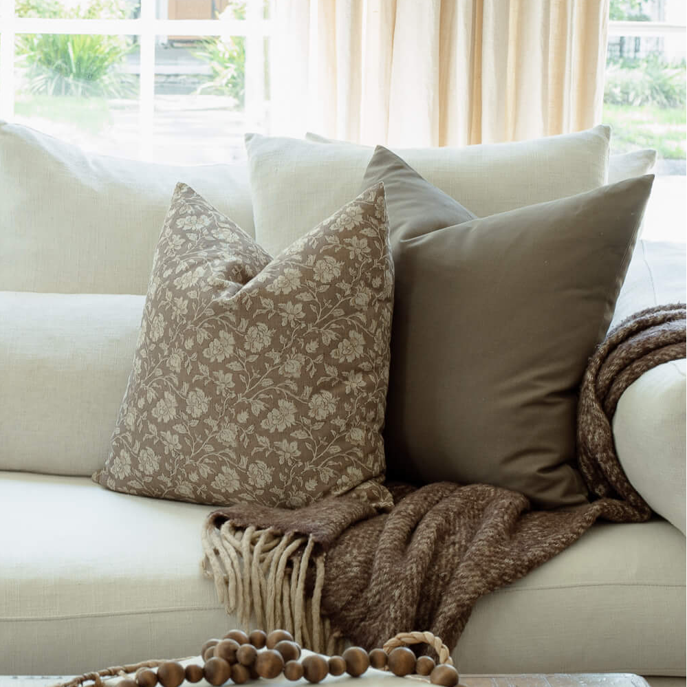 Clara taupe floral pillow on a neutral sectional