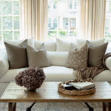 Clara taupe botanical pillow styled on a neutral sectional