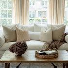 Mila tan floral pillow with sage ditsy pillows on an organic modern sofa
