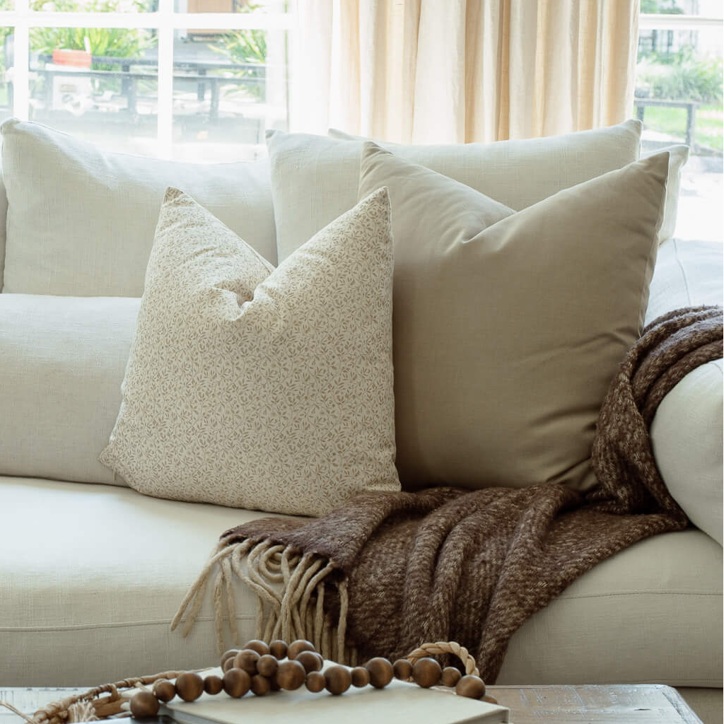 Mila neutral botanical pillow styled on an organic modern sofa