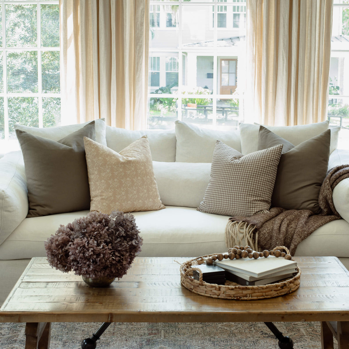 Fleur sand floral pillow with taupe and ivory pillows in an organic modern living room