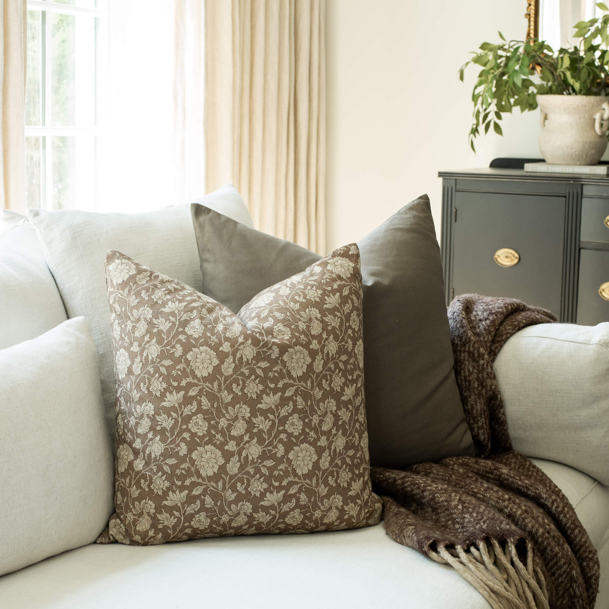 Madeleine taupe botanical throw pillow cover on a sofa