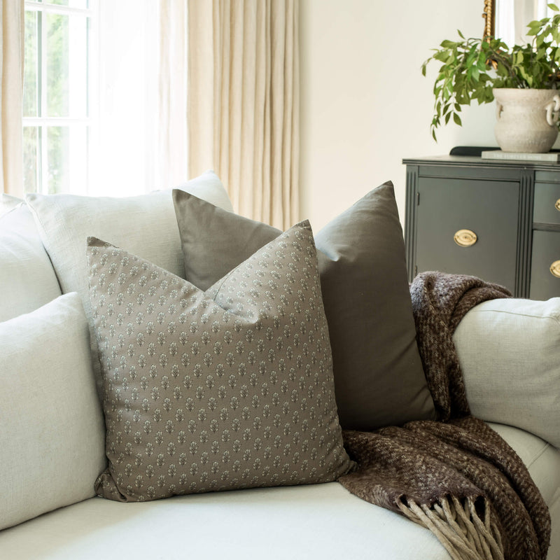 Simone taupe textured floral throw pillow cover on a sofa