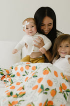 Blanket styled on twin bed with cheerful clementine design