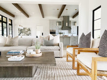 White and Beige Ticking Stripe Pillow Cover Resting on a couch 