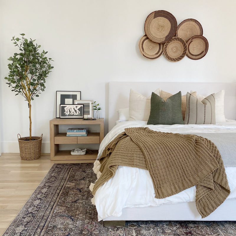 a bed with a bunch of pillows on it