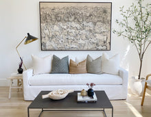 White and Beige Ticking Stripe Pillow Cover on a white couch