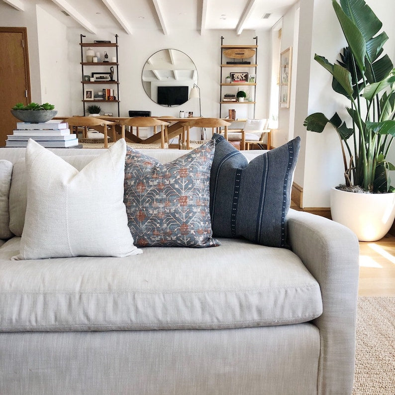 a bunch of pillows on a white couch