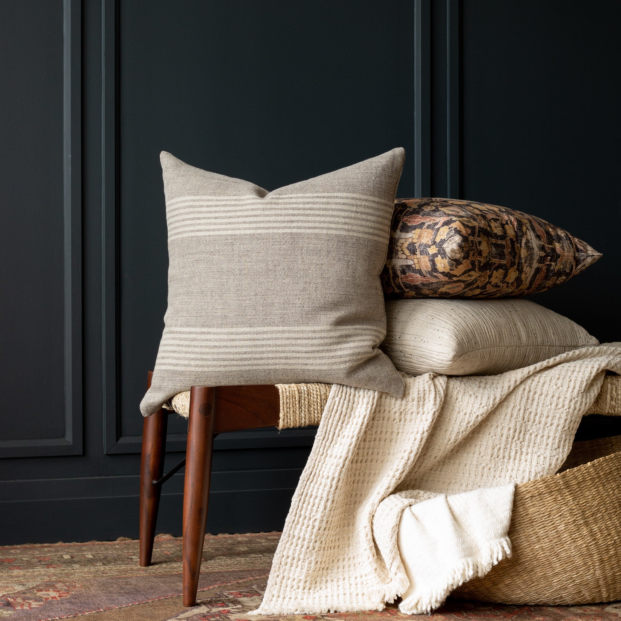 Stefanie Stripe Pillow Cover Resting on a bench beside other throw pillows
